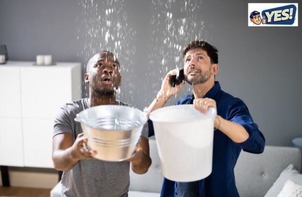 Two men, holding buckets catching leaking water from the ceiling in their living room, one talking YES! Plumbing on the phone to get water leak detection service in Salt Lake City. 